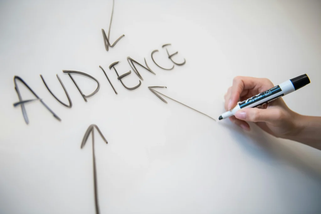 Hand writing "audience" on whiteboard