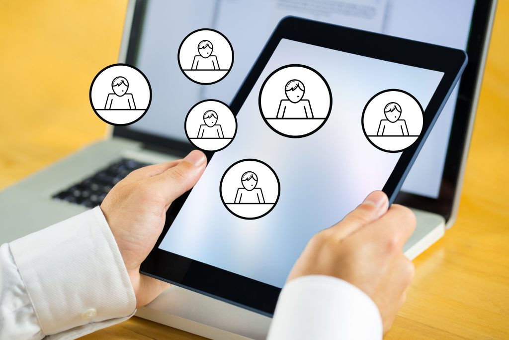 digital composite of hands using tablet computer with people graphics